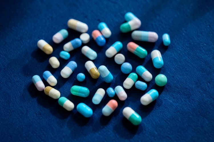 Vários tipos de comprimidos e cápsulas de antibióticos.
